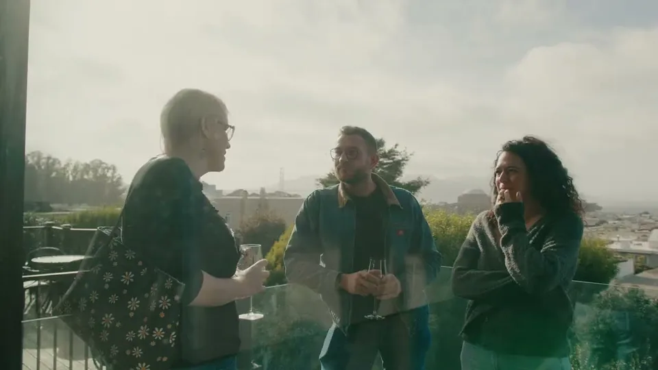 Guests talking over wine on a terrace above the city