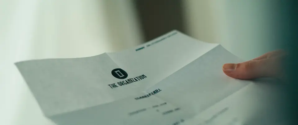 A hand holding a folded letter